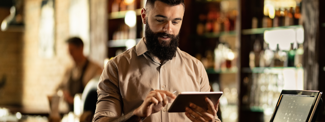 smiling-barista-using-digital-tablet-while-working-bar